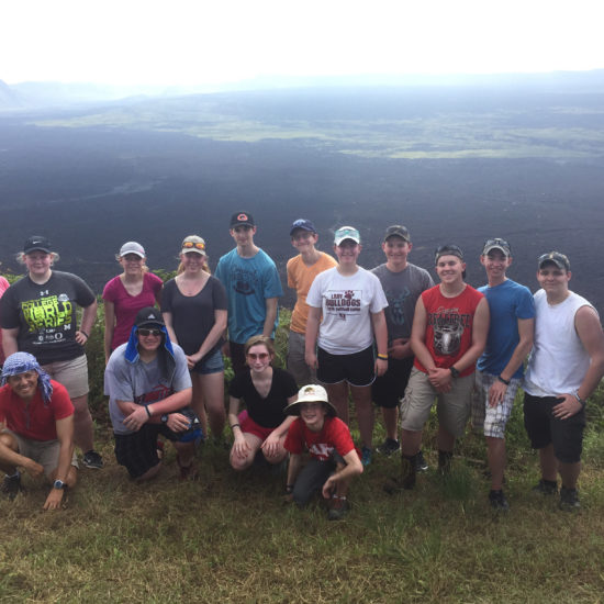 Group poses together on a mountain