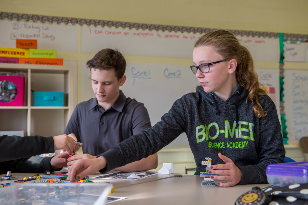 Female and male student work together with legos