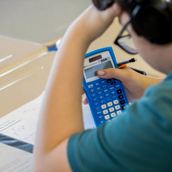 Male student using calculator